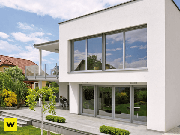 Modernes Einfamilienhaus mit großer Terrasse, bodentiefen Fenstern und gepflegtem Garten.